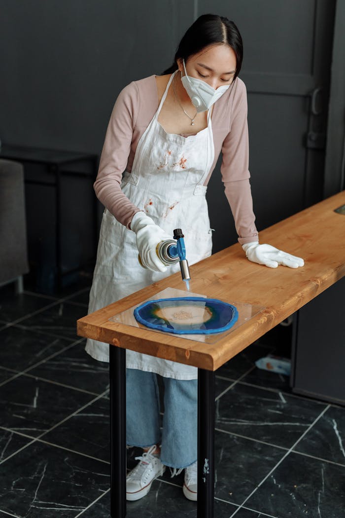 Artist uses blowtorch to create resin art indoors. Safety equipment included.